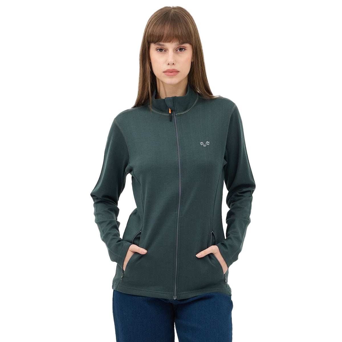 Žena v zelené propínací bundě z merino vlny – ruce v kapsách