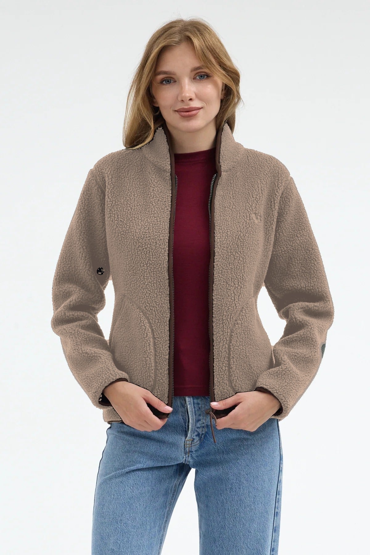 Béžová dámská bunda sherpa s merino vlnou uvnitř – rozepnutá, ruce v kapsách